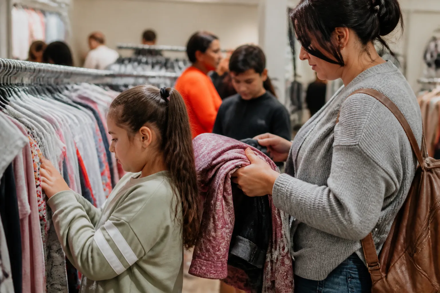 Children and caregivers choose clothing during a monthly free Shopping Day at Trey’s Boutique in Ralston.