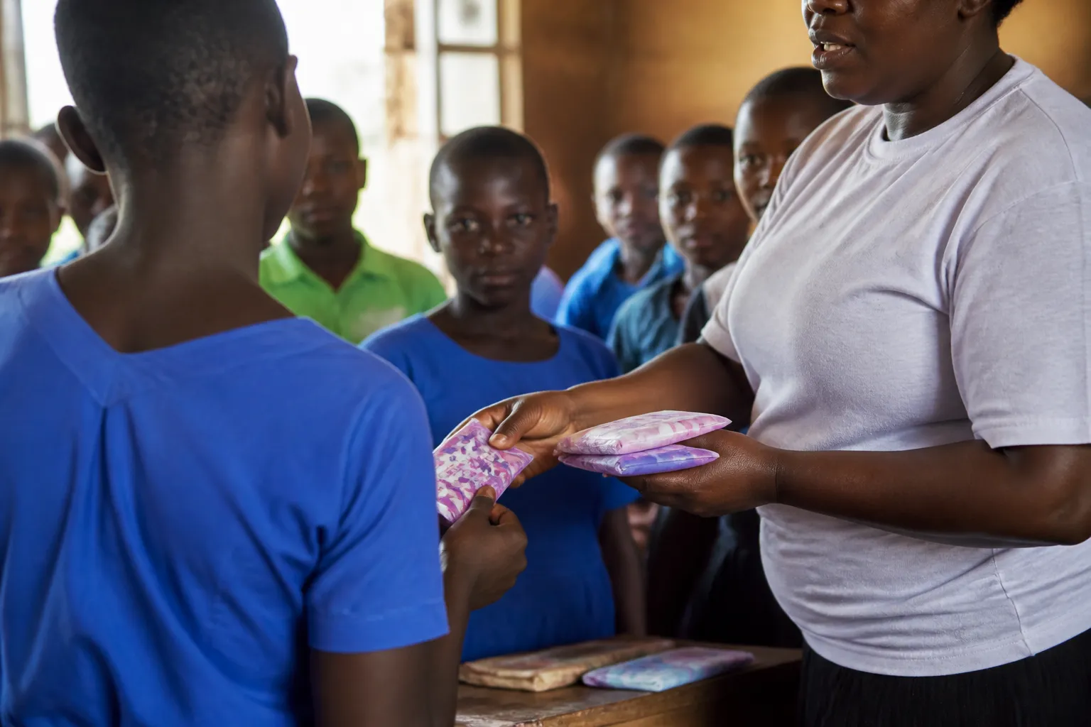 Girls at Bufulubi Primary School in Mayuge District receive reusable and disposable pads in daylight.