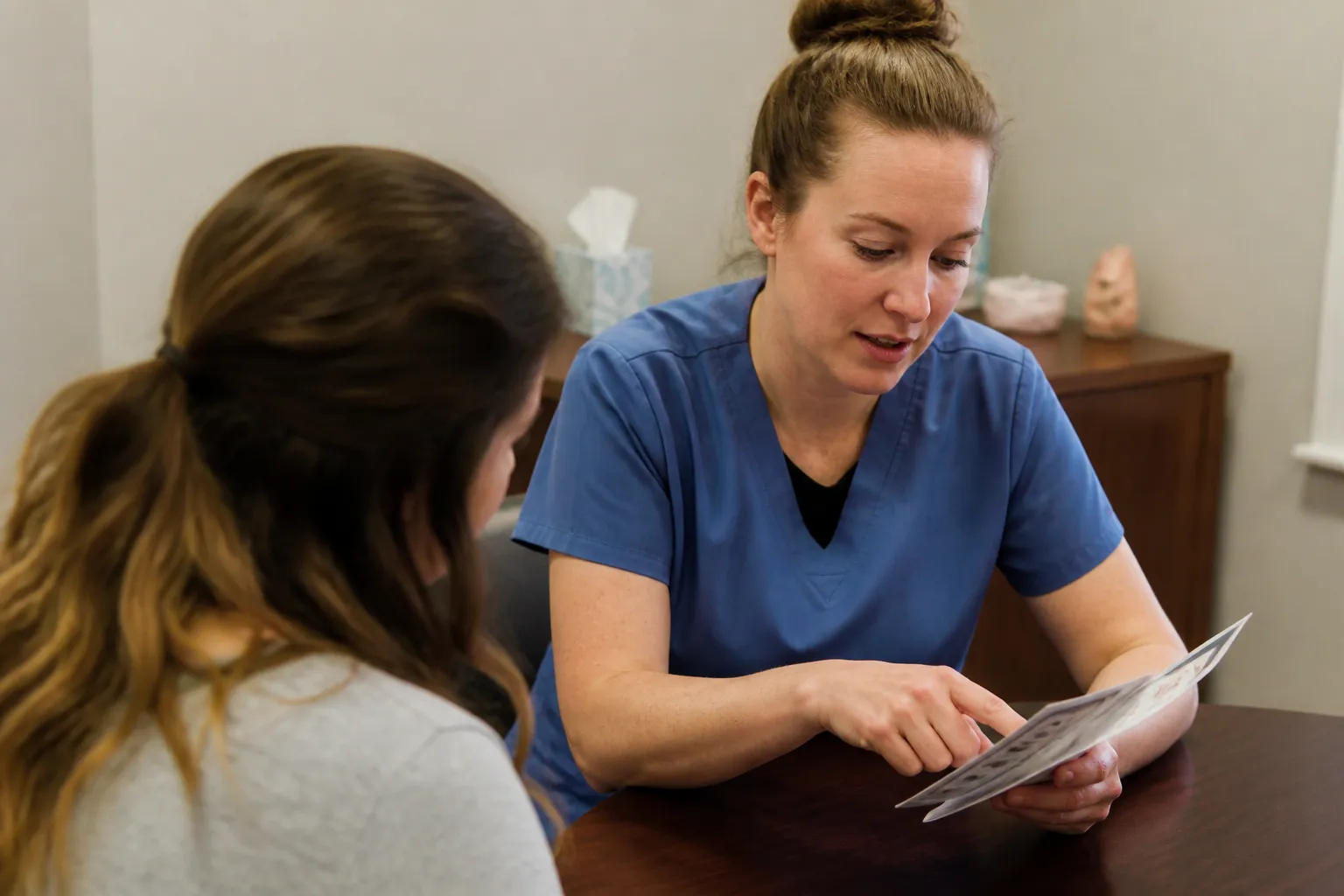 Nurse discusses test results with a client in a private consultation room at Essential Pregnancy Services.