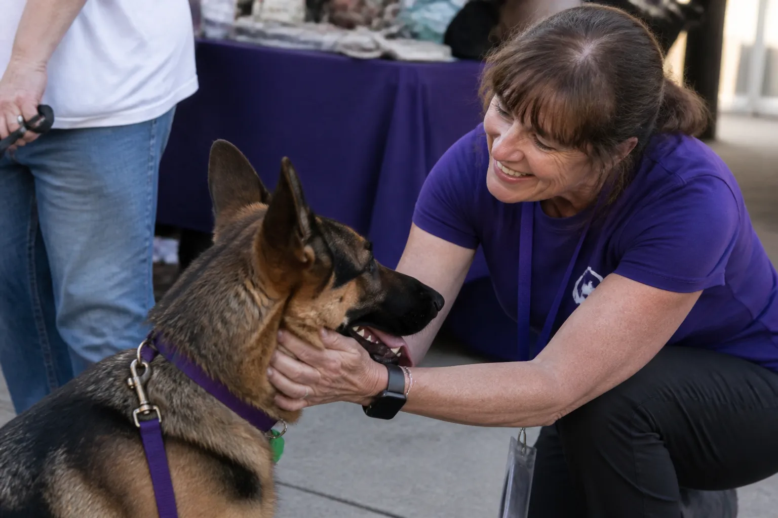 Forever Family Rescue volunteer greets a newly adopted German Shepherd at a partner adoption event.