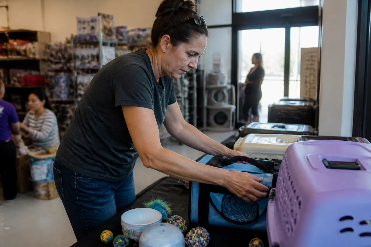 best animal charities to donate in Dallas: Rescue Me volunteer arranges carriers and toys for adoptable cats at a Petco Highland Village meet-and-greet.