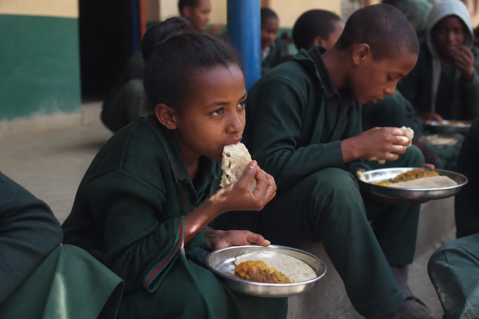Children sit at Galeya Rogdha School in Oromia during Engera’s daily meal program in daylight.