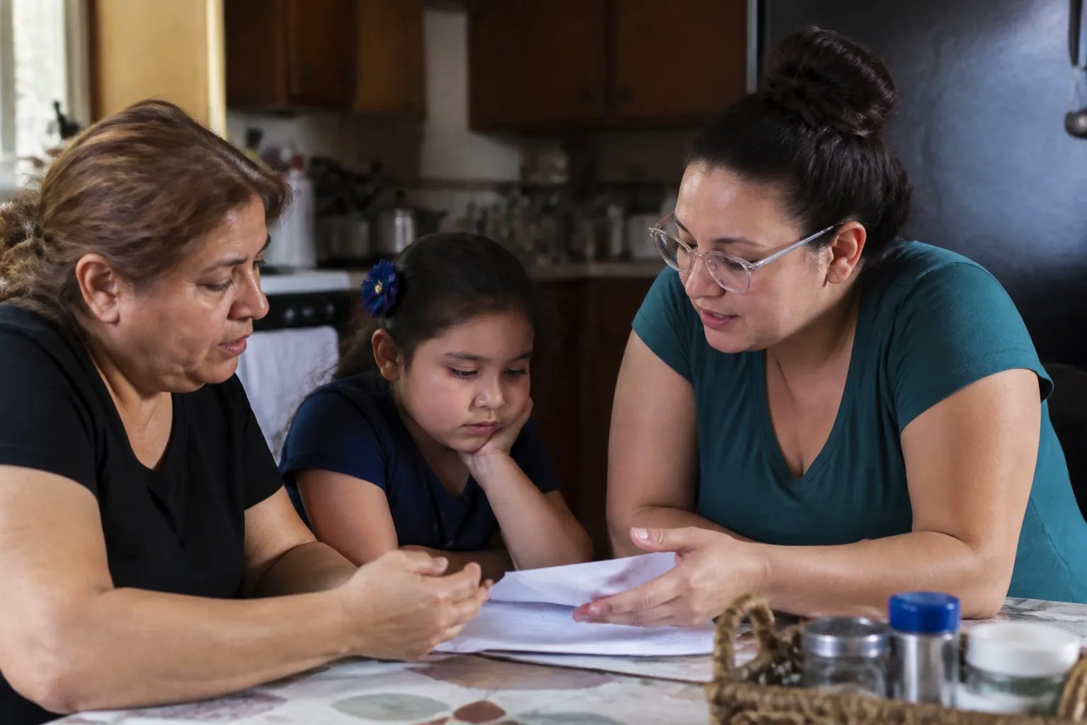 A Friend mentor reviews school papers to support youth mentoring in Houston during a home visit.