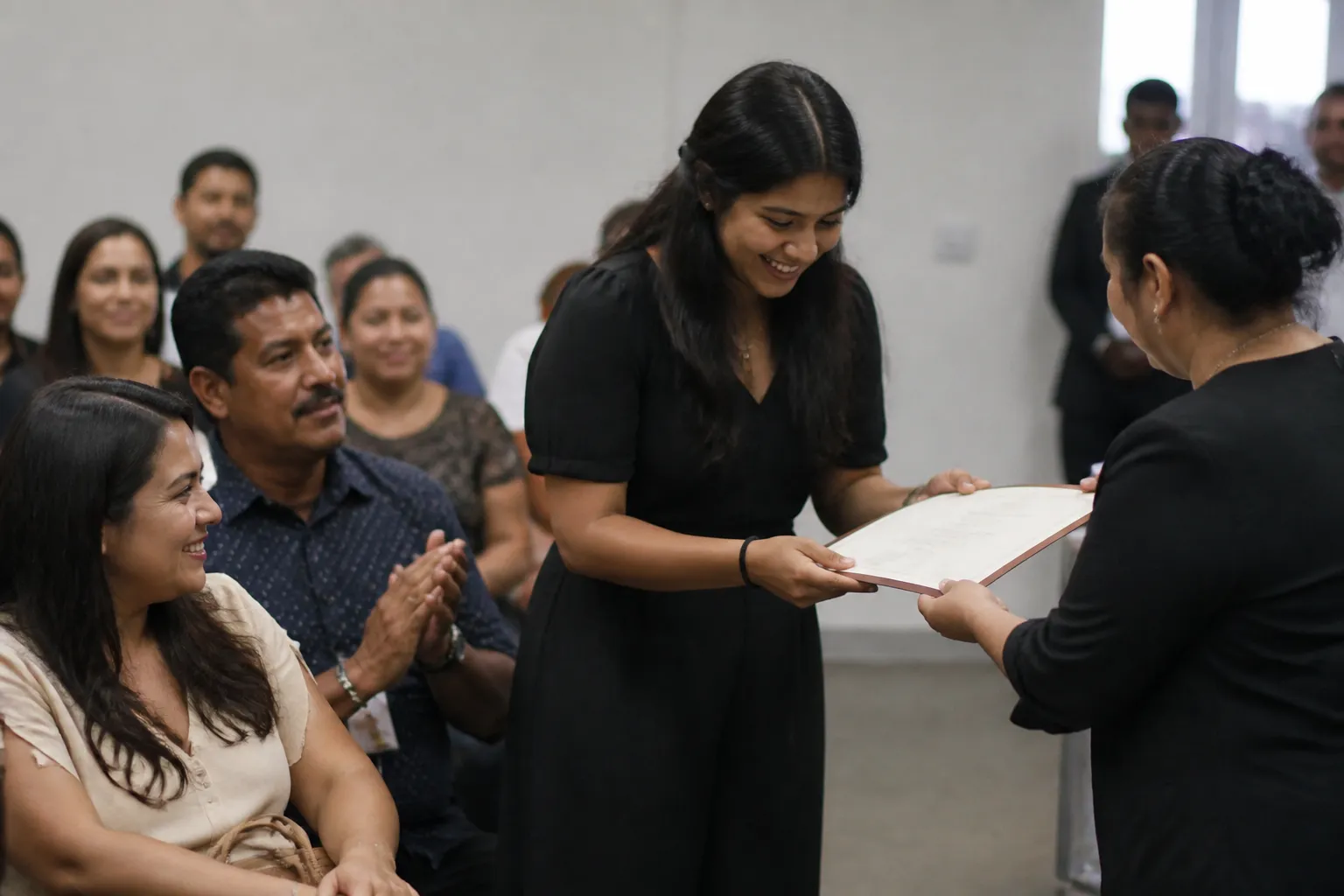 A high school senior receives an Azteca Scholarship certificate while family members watch at an event in Houston.