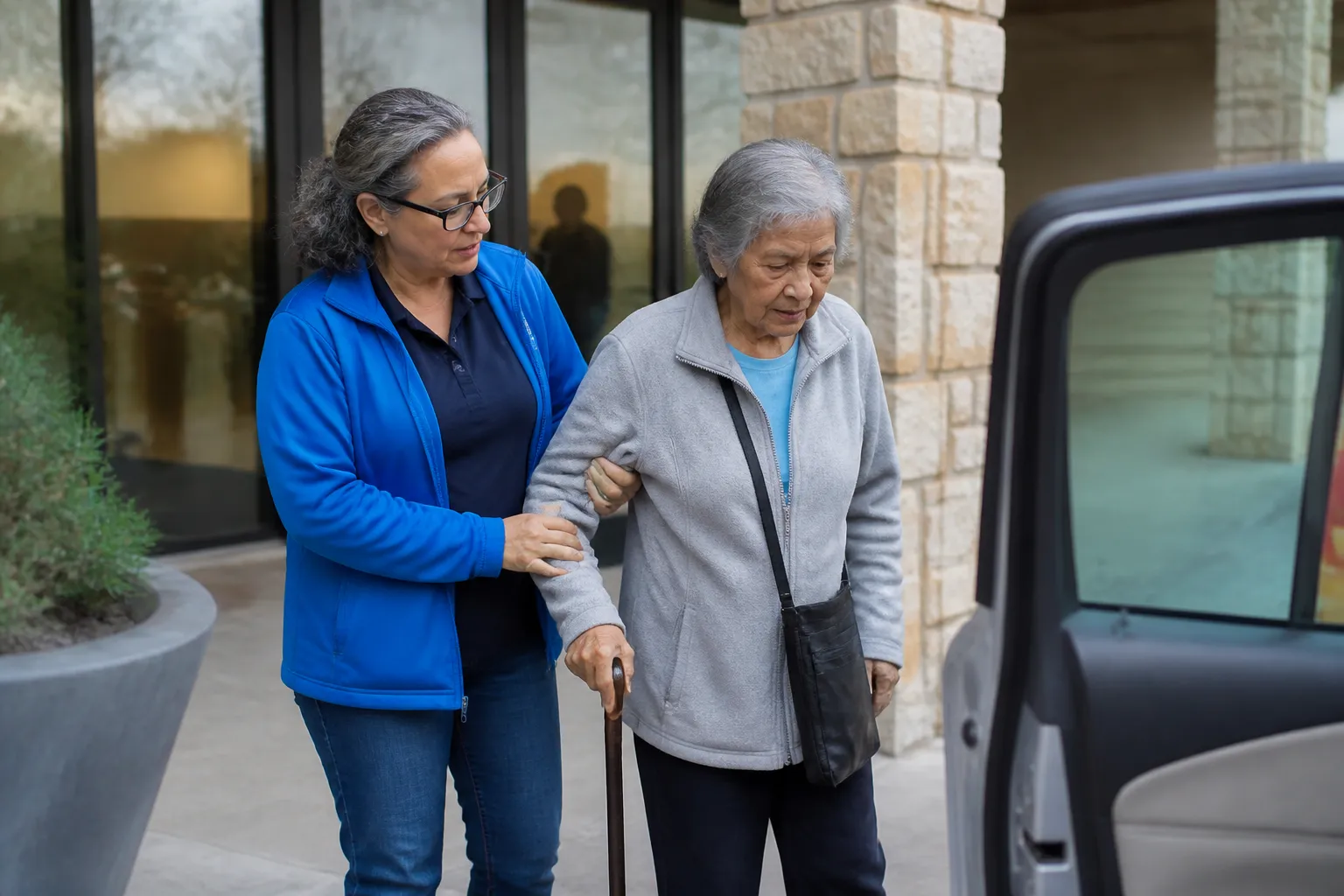 Drive a Senior Austin volunteer helps an older adult get to a clinic appointment at a curbside entrance.