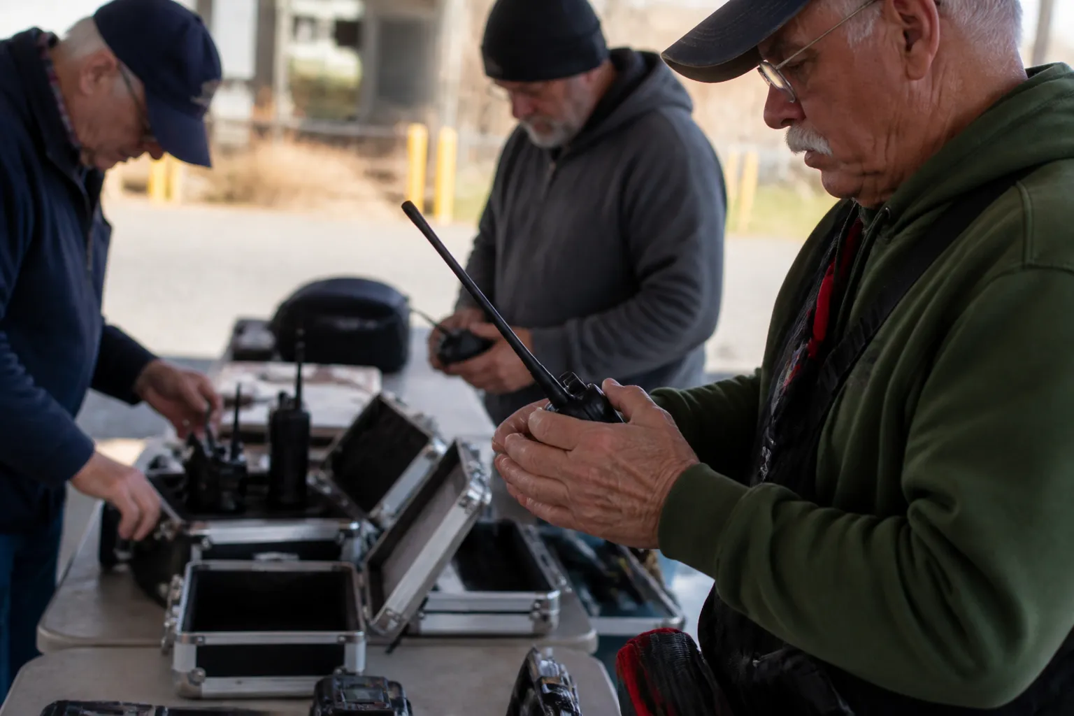 McKinney Amateur Radio Club volunteers check handheld radios and repeater gear as a practical example of how to help disaster preparedness in Dallas before a public-service assignment.