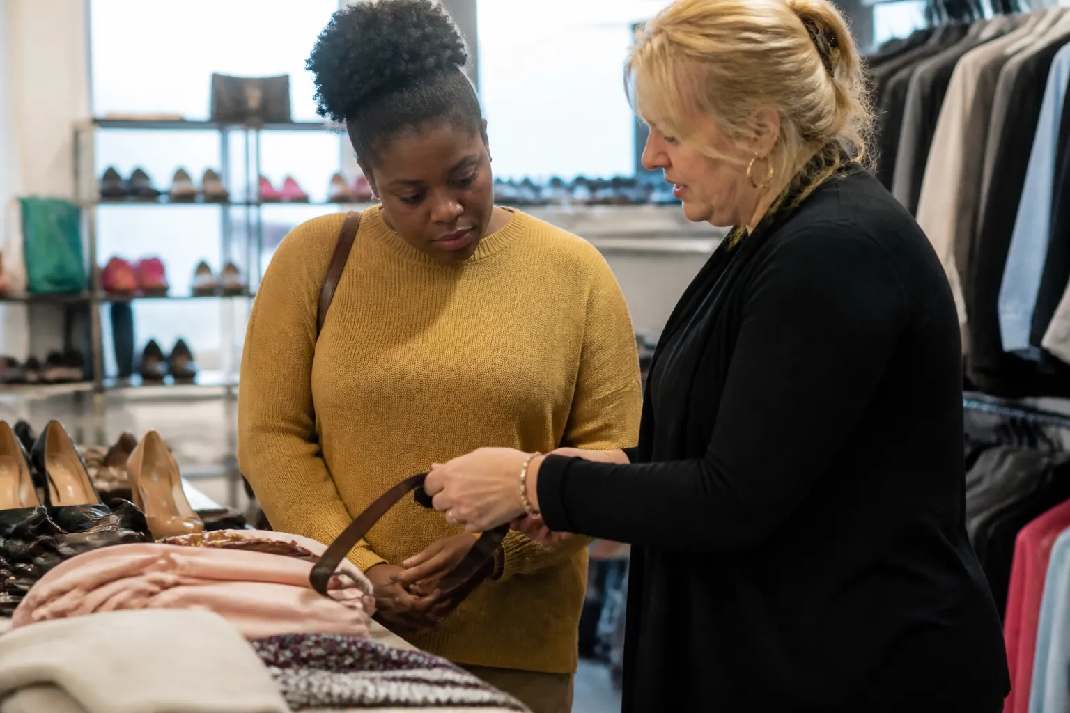 where to donate professional clothes for women in dallas tx: Dress for Success Dallas volunteer helps a client choose interview attire and accessories in the boutique.