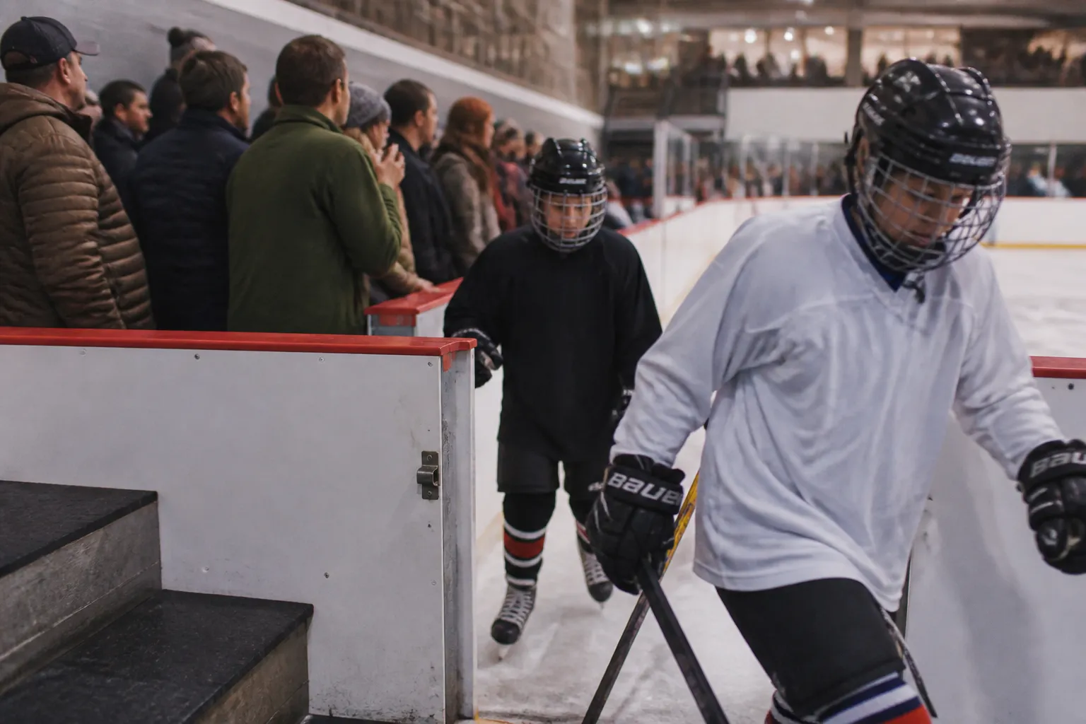 Youth hockey players enter the ice at Glacier Ice Rink while families watch a public skate session.