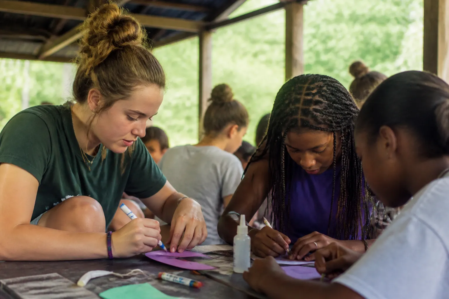 Pride Tree campers and counselors craft outdoors before swimming and hiking activities during summer camp.