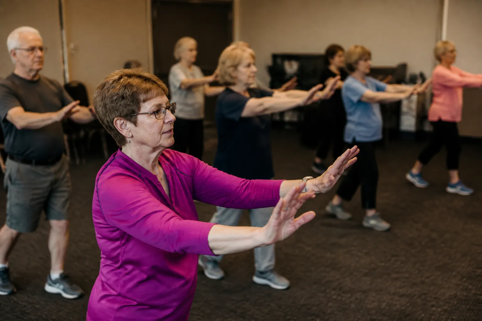 Dallas Area Parkinson Society class participants exercise together in a North Texas community room.