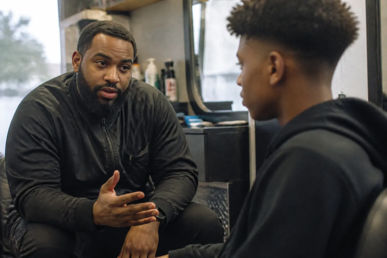 Barber mentor talks with a teen inside Visionary Youth’s MIND Mobile Barbershop in Lincoln.