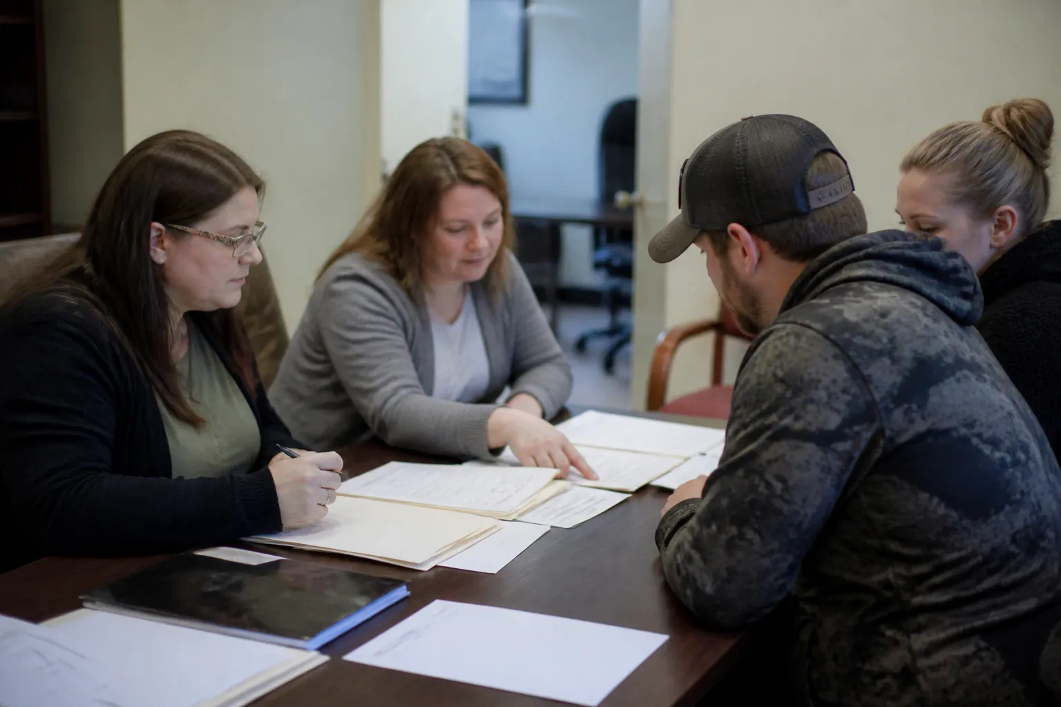 Arc of Lincoln staff and a family seated in a Lincoln office reviewing housing documents.