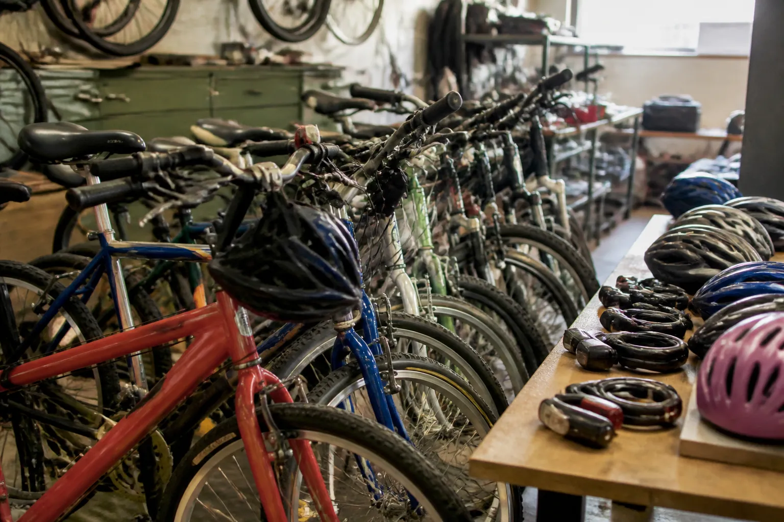 Refurbished bicycles with helmets, locks, and lights are staged inside Community Bicycle Shop for redistribution.
