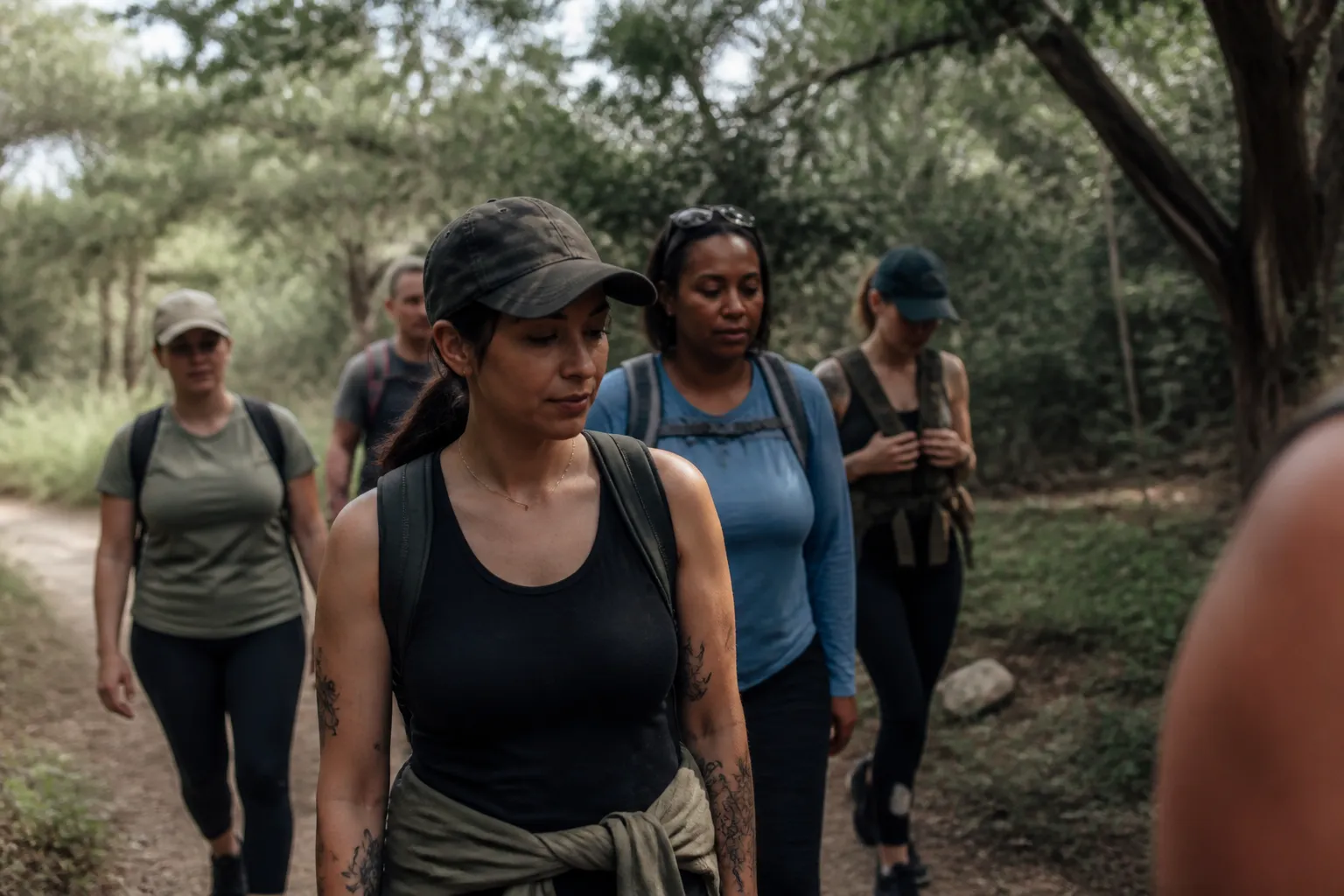 Women veterans in Austin TX walk on a wooded trail together during Heartspace Collective grounding session.