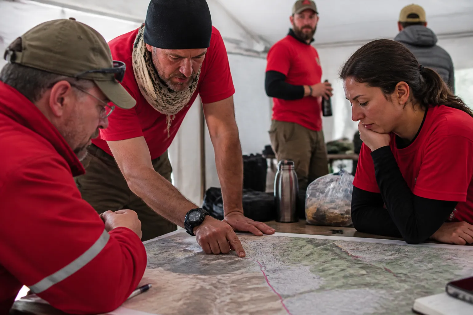 Red Rock Search And Rescue volunteers review search and rescue operations in Las Vegas at a command-post table.