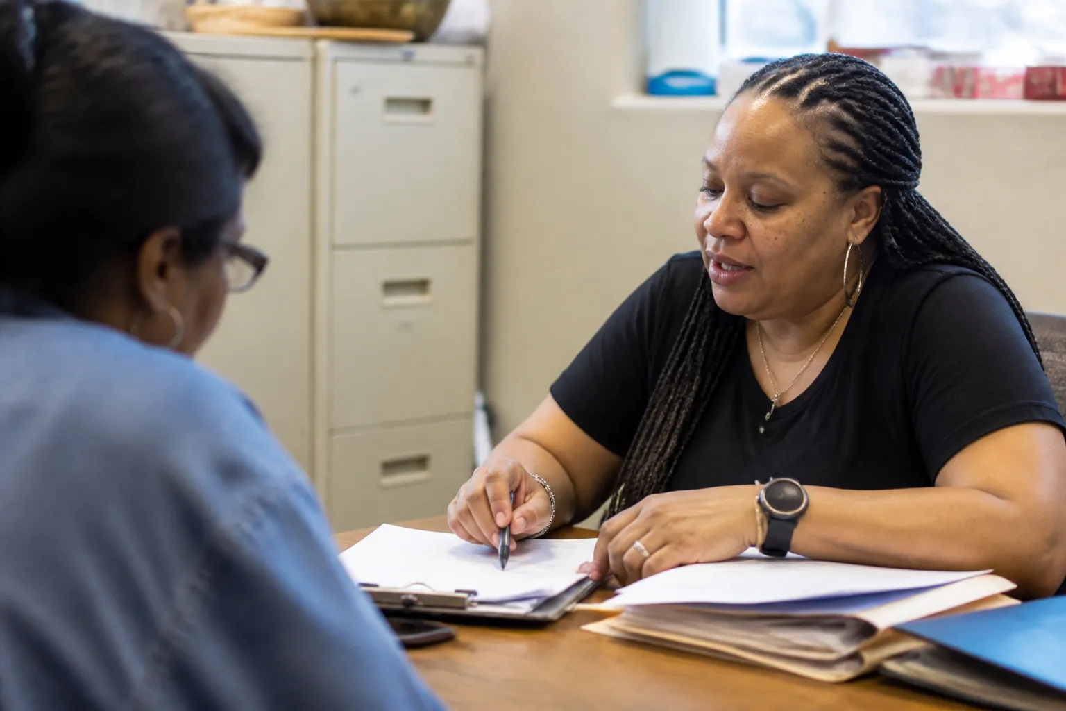 ICDC staff reviews credit and financing paperwork with a prospective homebuyer at a South Dallas table.