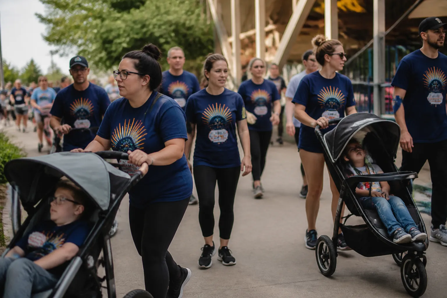 Families in Step UP Walk shirts push strollers at Discovery Playground during the annual Down syndrome fundraiser.