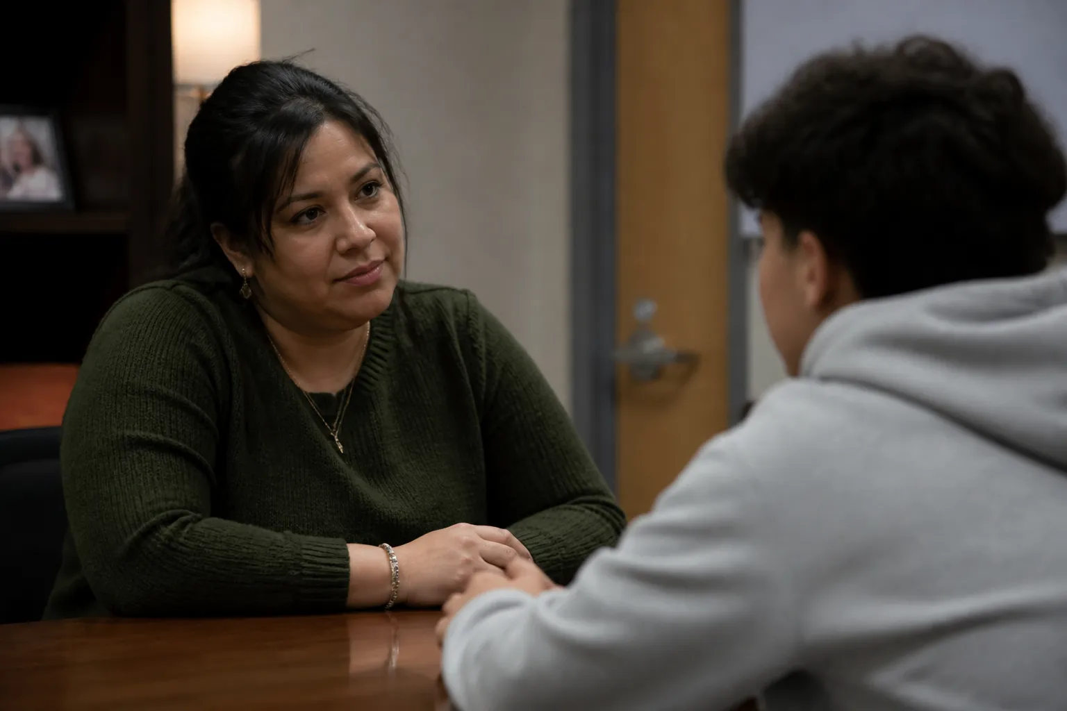 A Communities In Schools staff member holds a one-on-one counseling meeting with a student in a campus office.
