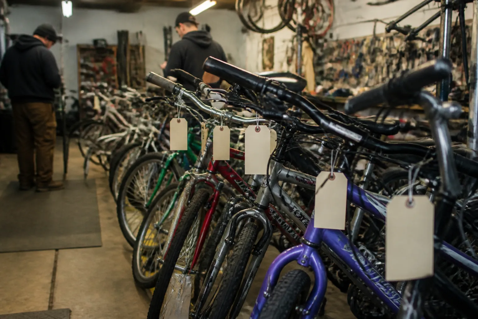 Donated bicycles wait in a row inside Community Bicycle Shop of Omaha for refurbishment and repair education as people consider where to donate bikes in Omaha.